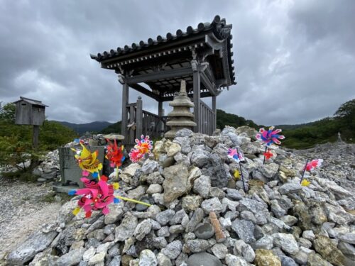 恐山の死者の弔いのため石が積まれた山と風車