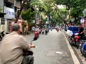 ハノイ旧市街の街の写真で、たくさんのバイクが行き来している