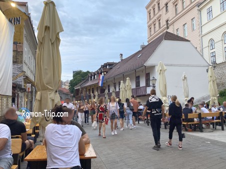 A peaceful solo dinner setting in Croatia, featuring an open terrace with charming cobblestone streets in the background. The ambient lighting and historic surroundings create a perfect atmosphere for an unforgettable evening.