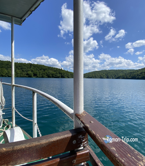 プリトヴィッツェ湖沼国立公園のコジャク湖クルーズ。船の中から青く澄んだ湖を望む穏やかな時間。/ Kozjak Lake cruise at Plitvice Lakes National Park, viewing the clear blue water from inside the boat in a peaceful moment.