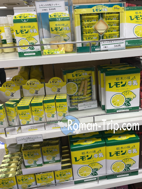 売店にずらりと並んだ栃木名物レモン牛乳の関連お土産。ドロップやキャラメルなど、バリエーション豊富なご当地スイーツが勢揃い。/ A colorful display of Tochigi’s lemon milk-themed souvenirs at the shop — including drops, caramels, and other fun local sweets.