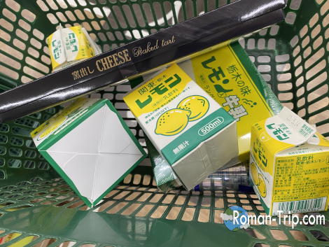 買い物かごに入れられた栃木名物レモン牛乳関連のお土産たち。ドロップやキャラメル、スイーツなどバラエティ豊かなご当地アイテムがずらり。/ A shopping basket filled with lemon milk-themed souvenirs from Tochigi — drops, caramels, and a variety of fun local treats inspired by the iconic drink.