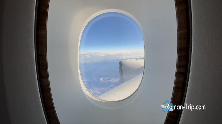 エミレーツ航空の飛行機の窓から見えた空の景色。機上から眺める雲と地平線が、旅の高揚感と非日常を感じさせてくれる瞬間。/ A view from the window of an Emirates flight — clouds and the distant horizon seen from above, capturing the excitement and wonder of being in the air.