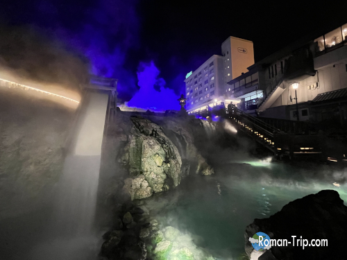 夜の草津温泉・湯畑。ライトアップされた湯けむりと温泉街の灯りが幻想的な雰囲気を醸し出す、心癒される夜の風景。/ Night view of the Yubatake in Kusatsu Onsen — a dreamlike scene with illuminated steam and warm lights from the surrounding hot spring town.