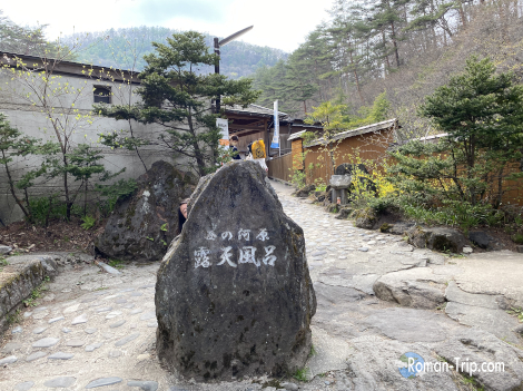 草津温泉・西の河原露天風呂の入口。自然に囲まれた大露天風呂へと続く道に、旅の期待感が高まる。/ Entrance to the Sainokawara open-air bath in Kusatsu Onsen — a path leading into a vast hot spring surrounded by nature, full of anticipation and tranquility.