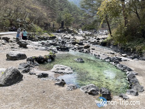 草津温泉・西の河原公園の下流にある足湯。せせらぎの音を聞きながら気軽に楽しめる、散策中の癒しスポット。/ Downstream footbath in Sainokawara Park, Kusatsu Onsen — a relaxing spot along the stream where visitors can soak their feet and unwind during a peaceful stroll.