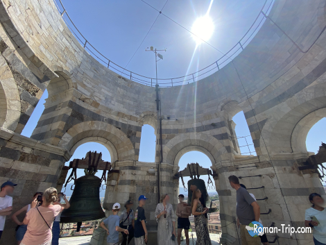 ピサの斜塔を見上げた一枚。青空の下、大きな鐘が見える美しい景色。/ Upward view of the Leaning Tower of Pisa with a large bell visible against the clear blue sky.
