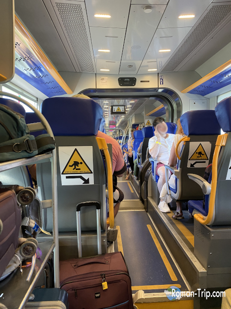 Leonardo Express（レオナルド・エクスプレス）の車内の様子。清潔で広々とした座席が並ぶ快適な空間。/ Interior view of the Leonardo Express — a clean and spacious setting with comfortable seating for a pleasant airport transfer.
