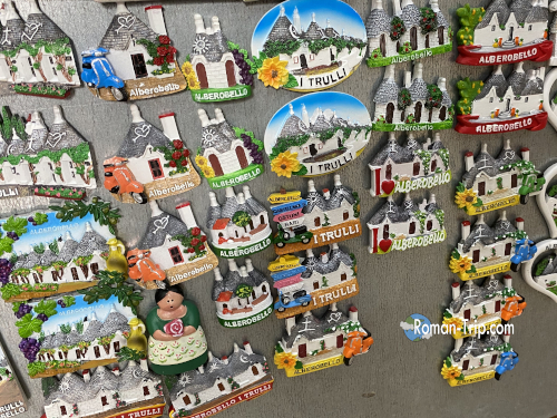 お土産屋に並ぶアルベロベッロのご当地マグネットたち。/ Local souvenir magnets of Alberobello displayed in a shop.