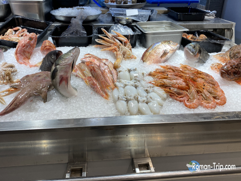 バーリで見つけたシーフードレストランの店頭に並ぶたくさんの新鮮な魚介類。海の幸の豊かさを感じさせる光景。/ Fresh seafood piled high at the storefront of a restaurant in Bari — a vivid display of the region’s rich bounty from the sea.