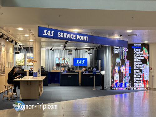 コペンハーゲン空港にある航空会社SASのサービスカウンター。手続きや問い合わせを行う旅行者でにぎわう場所。/ SAS service counter at Copenhagen Airport — a busy spot where travelers handle check-ins, inquiries, and assistance.