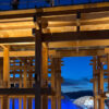 関西万博の夜の大屋根リング。ライトアップされ黄金色に輝く幻想的な光景。/ Night view of the Grand Roof Ring at Expo Osaka, illuminated in golden light creating a magical atmosphere.