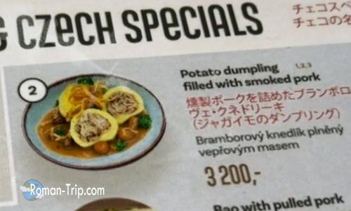 チェコパビリオンのメニューに載っているブランボロヴェクネドリーキ。伝統的なチェコ料理として紹介されている。/ Bramborové knedlíky featured on the menu at the Czech Pavilion, presented as a traditional Czech dish.