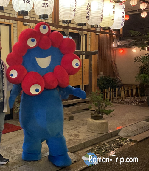 万博開幕の一年以上前、初詣に登場したミャクミャク。人々に笑顔を届ける姿が印象的。/ Myakumyaku appearing at a New Year’s shrine visit over a year before the Expo opening, delighting visitors with its cheerful presence.