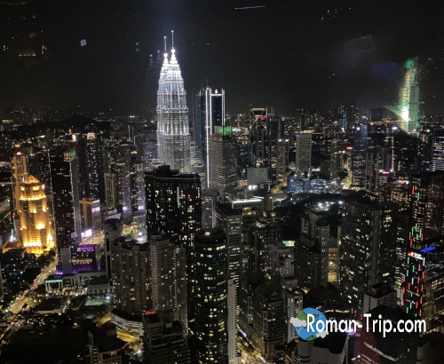 KLタワーから見たペトロナスツインタワーの夜景。輝くツインタワーとクアラルンプールの街明かりが美しい。/ Night view of the Petronas Twin Towers from KL Tower, with the illuminated towers and Kuala Lumpur city lights creating a stunning scene.