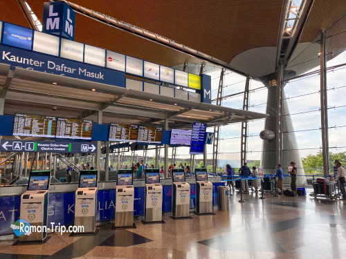 クアラルンプール国際空港の国際線チェックインカウンター。次の国へ向かう出発前のひととき。/ International check-in counters at Kuala Lumpur International Airport, moments before departing for the next destination.