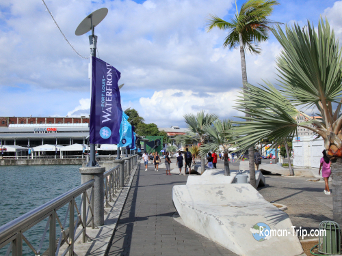 モーリシャスの首都ポートルイスの海岸沿いの景色。青い海と港町の建物が広がる爽やかな風景。/ Coastal view of Port Louis, Mauritius, featuring the blue sea and the charming harbor town scenery.