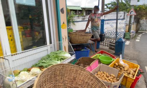 モーリシャス東部の町トゥルードースドゥースの個人商店。店先にはジャガイモや菜っ葉などの野菜が積まれて売られている。/ A small local shop in Trou d’Eau Douce, eastern Mauritius, with baskets of potatoes and leafy vegetables displayed for sale.