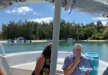 イル・オ・セルフの船着き場に到着。白い砂浜に舟が停泊し、透明な海が広がる南国の楽園のような光景。/ Arrival at the Île aux Cerfs boat jetty — boats resting on the white sandy shore and crystal-clear waters creating a tropical paradise view.