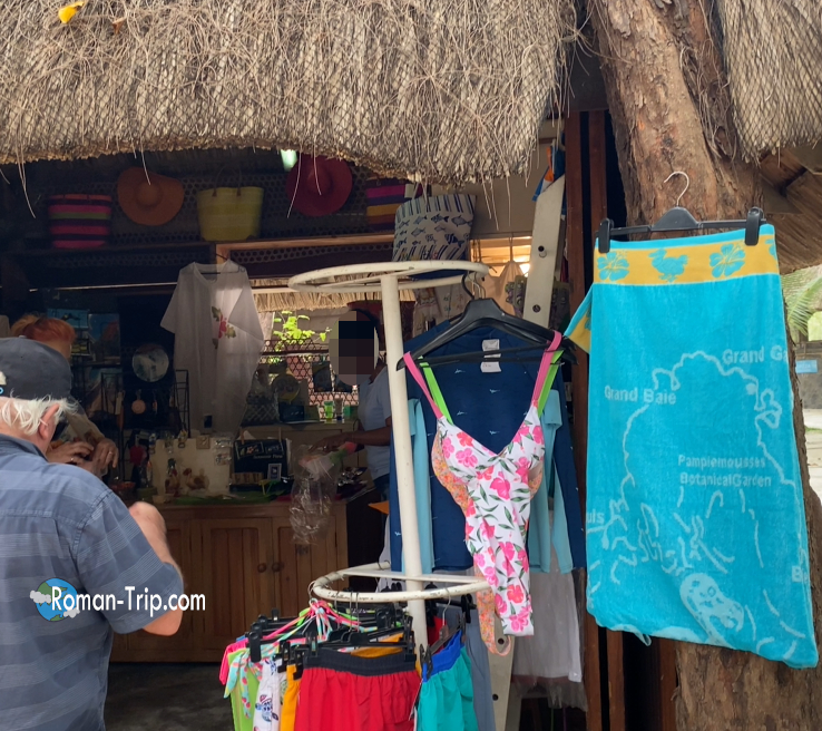 モーリシャスのイル・オ・セルフ島にあるお土産屋の内部。水着やビーチタオル、南国らしい雑貨が所狭しと並ぶ。/ Inside a souvenir shop on Île aux Cerfs, Mauritius, filled with swimsuits, beach towels, and tropical island goods.