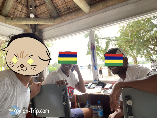 モーリシャスのイル・オ・セルフ島でスタッフの男性と女性と一緒に記念撮影。ちょっとしたハプニングも含めて、今では笑えるいい思い出。/ A commemorative photo with male and female staff on Île aux Cerfs, Mauritius — despite a small mishap, it became a fond and unforgettable memory.