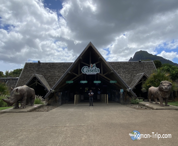 モーリシャスのCasela Nature Parksの正面入り口。サイとライオンのモニュメントが来園者を迎える迫力あるエントランス。 / Front entrance of Casela Nature Parks in Mauritius, featuring impressive rhinoceros and lion monuments welcoming visitors.