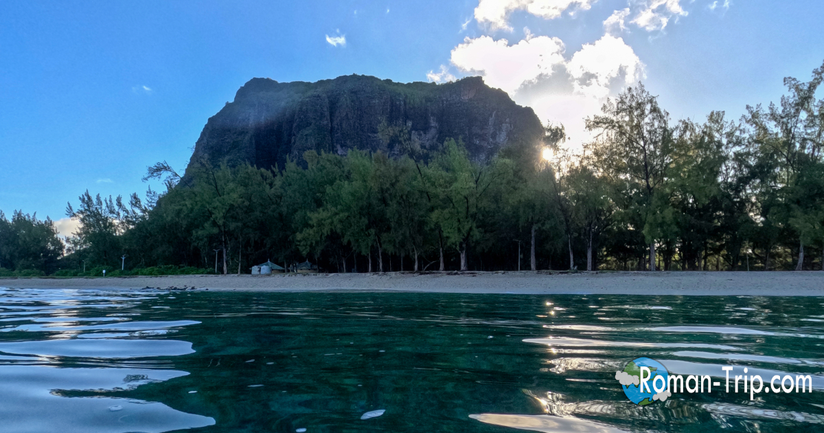 ルモーンビーチの沖合から眺めた、朝日が差し込むルモーン山。海上から見る山肌がやわらかく照らされ、静かな朝の始まりを感じる瞬間。/ Le Morne Mountain illuminated by the rising sun, photographed from offshore near Le Morne Beach, capturing a serene and peaceful morning in Mauritius.