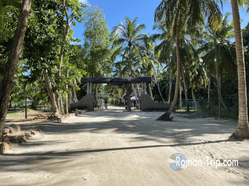 セーシェル・ラディーグ島のアンスースダルジャン（Anse Source d'Argent）へ向かう有料エリアの入口。ヤシの木に囲まれたビーチアクセスゲート。 / Entrance to the paid access area leading to Anse Source d'Argent on La Digue Island in Seychelles, surrounded by palm trees and tropical scenery.