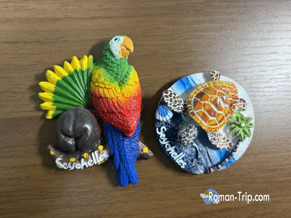 セーシェルのエデン島で買ったご当地マグネット。カラフルなオウムとヤシの実、そしてウミガメのデザインを旅の記念に選んだ。/ Souvenir magnets bought on Eden Island in Seychelles, featuring a colorful parrot, coconut, and sea turtle chosen as trip memories