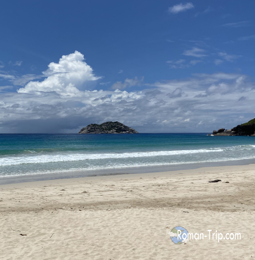 セーシェルのグランド・アンス・ビーチの風景。広がる白砂と青い海が美しい、開放感あふれるビーチ。 / Scenic view of Grand Anse Beach in Seychelles, featuring wide white sands and a vibrant blue ocean.