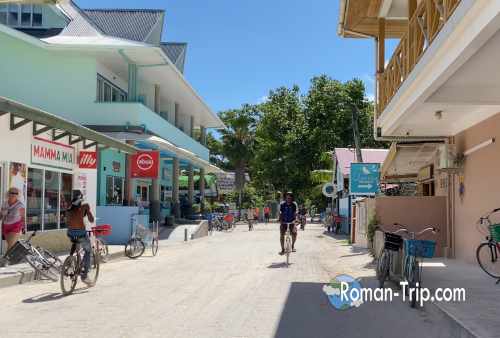 セーシェルのラディーグ島にある唯一の商店街。自転車が行き交い、南国の小さな島らしいのんびりした雰囲気の通り。 / The main shopping street of La Digue Island in Seychelles, where bicycles pass through a relaxed street lined with small island shops.
