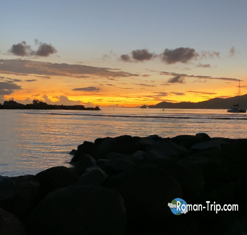 セーシェルのラディーグ島で見た夕日の風景。静かな海と南国の空がオレンジ色に染まる、島の一日の終わりの瞬間。 / Sunset on La Digue Island in Seychelles, where the calm sea and tropical sky glow in warm orange light at the end of the day.