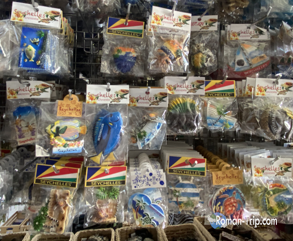 セーシェル・ラディーグ島のお土産屋に売られていたご当地マグネット。ウミガメなど南国モチーフのマグネットが袋詰めで並ぶ売り場の様子。 / Souvenir magnets sold at a shop on La Digue Island in Seychelles, with sea turtle and other tropical-themed magnets packaged together in display bags.