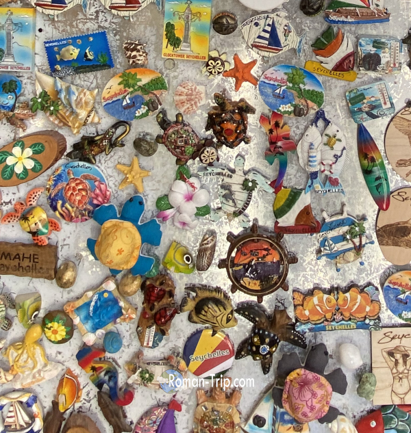 セーシェル・ラディーグ島のお土産屋に並んでいたご当地マグネットの数々。セーシェル国旗、ヒトデ、ウミガメなど南国の海をモチーフにしたデザイン。 / A variety of souvenir magnets displayed at a shop on La Digue Island in Seychelles, featuring designs such as the Seychelles flag, starfish, and sea turtles.