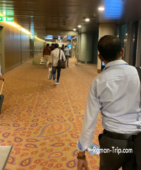 ムンバイ空港のイミグレーションに向かう通路。到着後の緊張感と移動の流れが伝わる空港内の風景。/ Corridor leading to immigration at Mumbai airport, capturing the airport atmosphere and movement just after arrival