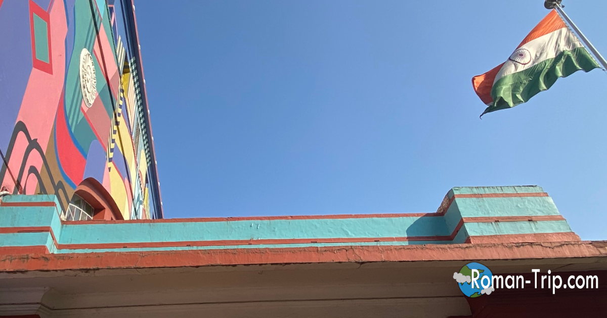 Mumbai Central駅のカラフルな外観とインド国旗。ここからインド半日観光が始まる、旅の高揚感がにじむ一枚。/ Colorful exterior of Mumbai Central station with the Indian flag, marking the exciting start of a half-day sightseeing trip in India