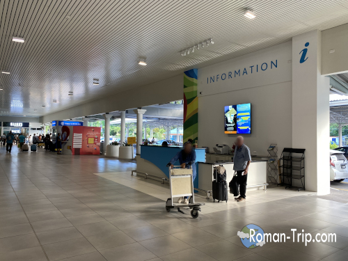 セーシェルのヴィクトリア空港（セーシェル国際空港）の到着エリアの様子。インフォメーションカウンターがあり、南国の島に到着した旅人を迎える空港の風景。 / The arrival area of Seychelles International Airport in Victoria, featuring an information counter welcoming travelers arriving on the tropical island.