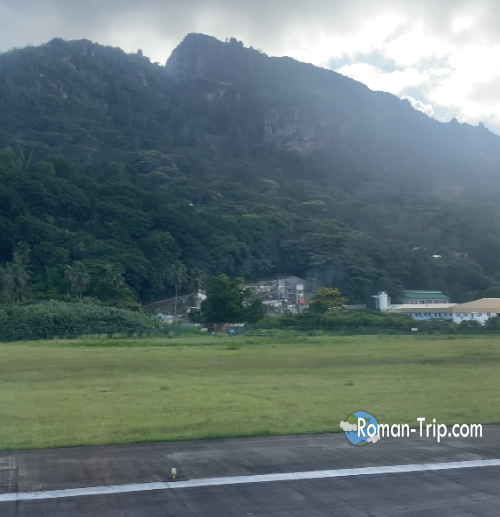 セーシェル・ヴィクトリア空港に着陸したときの風景。南国の海のイメージとは違い、空港の周囲には意外にも山々がそびえている。 / The view while landing at Victoria Airport in Seychelles, where surprisingly steep mountains rise around the airport beyond the tropical coastline.