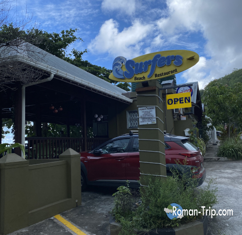 セーシェルのSurfers Beach Restaurantの外観。サーフボードの看板が南国らしい雰囲気を引き立てていた。/ Exterior of Surfers Beach Restaurant in Seychelles, featuring a surfboard sign that adds a tropical island atmosphere